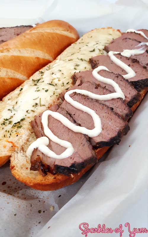 Slow wood smoked brisket on a cheesy garlic bread. You are going to fall in love with this sandwich. 