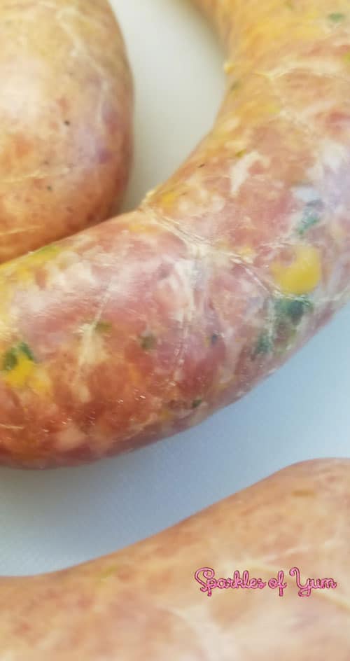 Close up view of an uncooked Homemade Jalapeno Cheddar Brat.