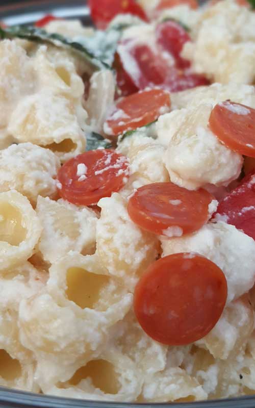 Fresh tomato and basil come together with a few other ingredients to make a simple Cheesy Italian Pasta Salad with a huge depth of flavor.