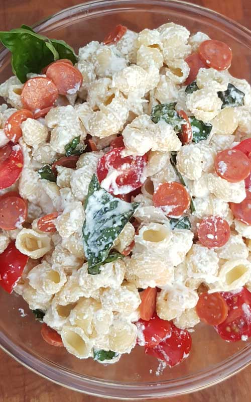 Fresh tomato and basil come together with a few other ingredients to make a simple Cheesy Italian Pasta Salad with a huge depth of flavor.
