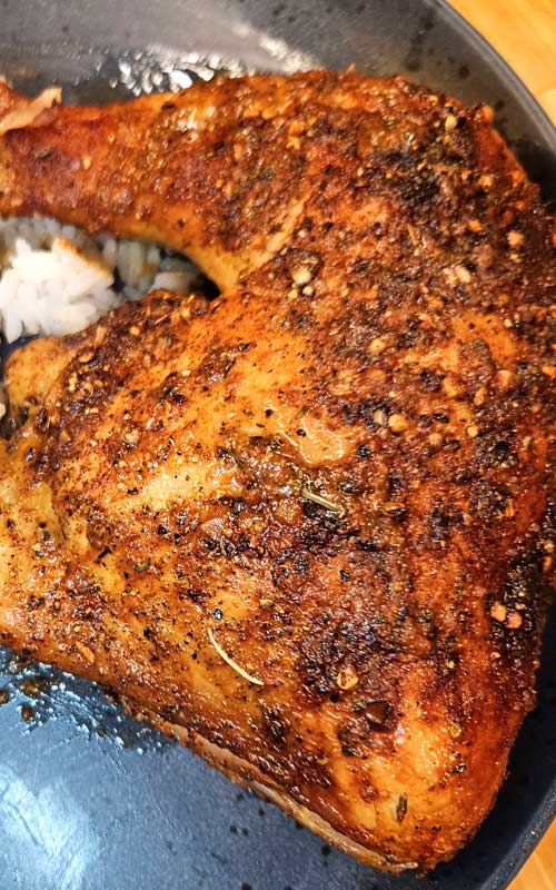 Baked chicken leg quarter on a blue plate.