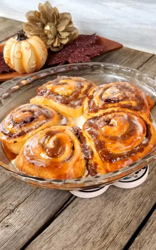 These Super Easy Pumpkin Butter Cinnamon Rolls are toasty warm, fresh from the oven. They are so delicious, extra rich, and gooey with spiced pumpkin butter and melty cream cheese frosting and a little caramel drizzle to top it all off with.