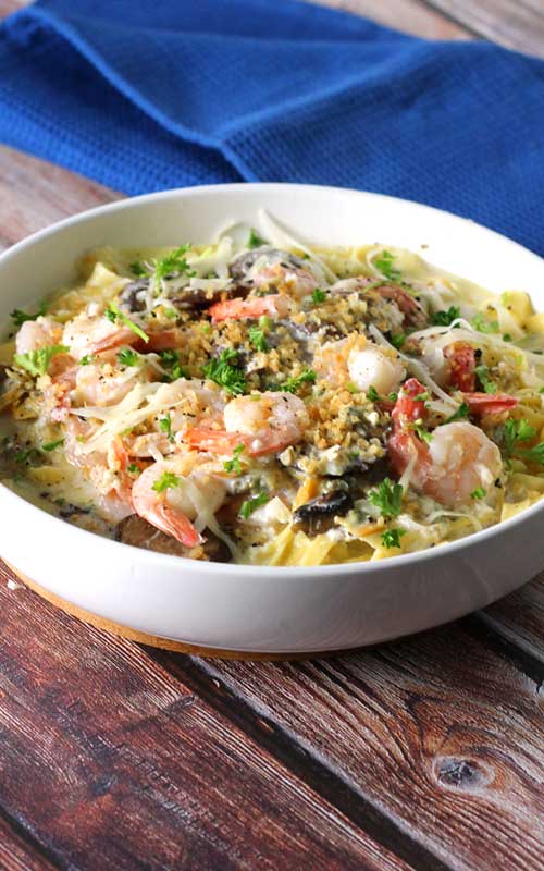 When shrimp, crab, clams, and mushrooms come together in a luscious creamy, cheesy garlic sauce over fresh pasta, you get this delectable Seafood Alfredo Fettuccine!