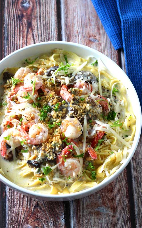 When shrimp, crab, clams, and mushrooms come together in a luscious creamy, cheesy garlic sauce over fresh pasta, you get this delectable Seafood Alfredo Fettuccine!