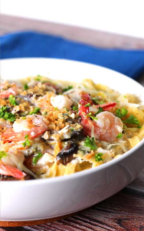 When shrimp, crab, clams, and mushrooms come together in a luscious creamy, cheesy garlic sauce over fresh pasta, you get this delectable Seafood Alfredo Fettuccine!