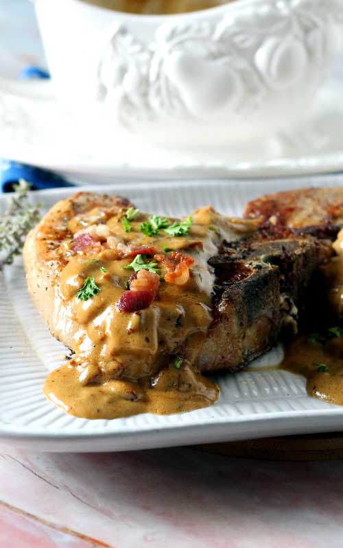 Bacon Gravy Smothered Pork Chops are just the comfort food we needed right about now! Take an everyday pork chop dinner to a whole other level of yum!