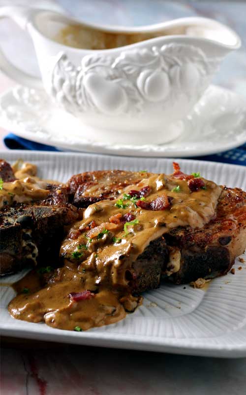 Bacon Gravy Smothered Pork Chops are just the comfort food we needed right about now! Take an everyday pork chop dinner to a whole other level of yum!