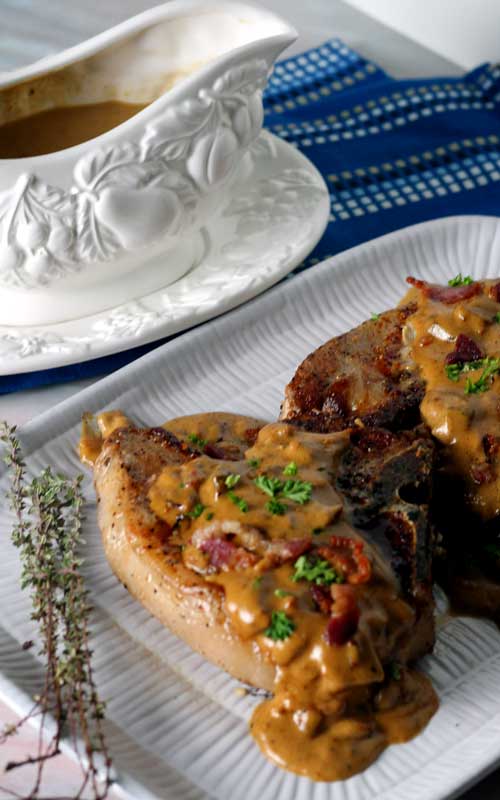 Bacon Gravy Smothered Pork Chops are just the comfort food we needed right about now! Take an everyday pork chop dinner to a whole other level of yum!