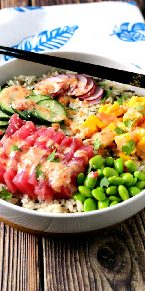 An absolutely divine Hawaiian Tuna Poke Bowl with fresh ahi tuna, bright crisp radish, cucumber, edamame, and sweet mango over wild rice with a drizzle of sweet chili aioli? Yes, please!