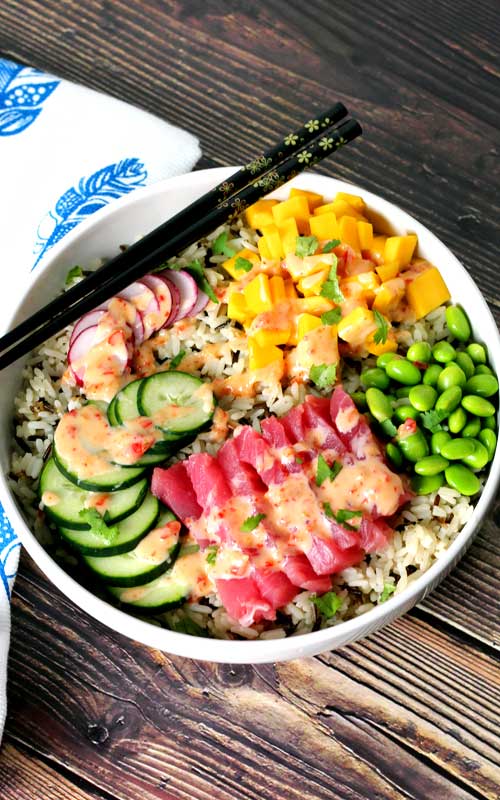 An absolutely divine Hawaiian Tuna Poke Bowl with fresh ahi tuna, bright crisp radish, cucumber, edamame, and sweet mango over wild rice with a drizzle of sweet chili aioli? Yes, please!