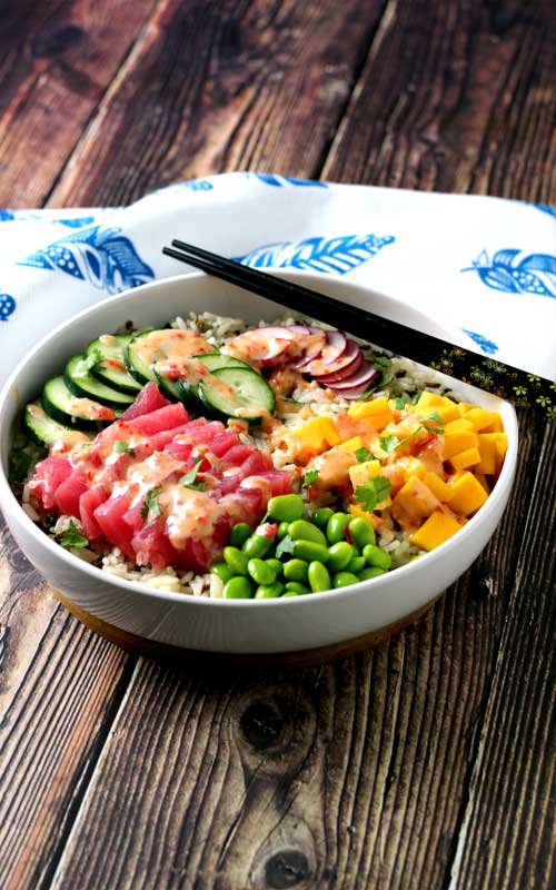 An absolutely divine Hawaiian Tuna Poke Bowl with fresh ahi tuna, bright crisp radish, cucumber, edamame, and sweet mango over wild rice with a drizzle of sweet chili aioli? Yes, please!