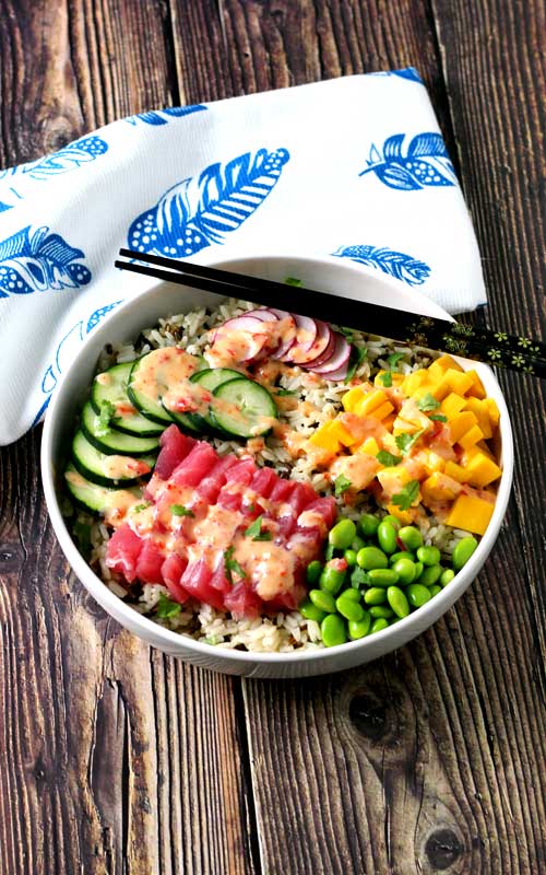 An absolutely divine Hawaiian Tuna Poke Bowl with fresh ahi tuna, bright crisp radish, cucumber, edamame, and sweet mango over wild rice with a drizzle of sweet chili aioli? Yes, please!