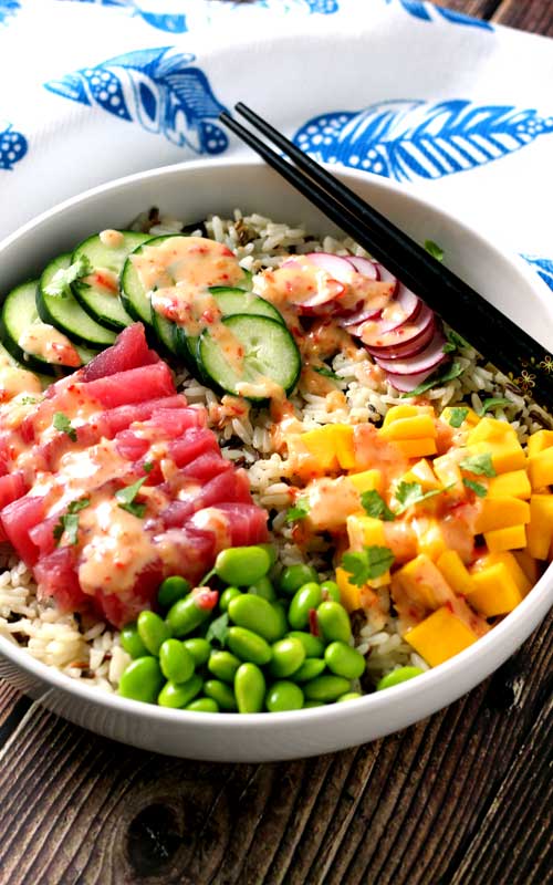 An absolutely divine Hawaiian Tuna Poke Bowl with fresh ahi tuna, bright crisp radish, cucumber, edamame, and sweet mango over wild rice with a drizzle of sweet chili aioli? Yes, please!