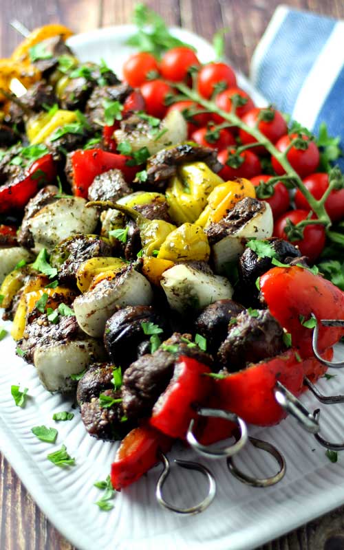 Metal skewers covered in grilled steak and vegetables.