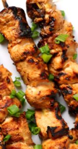 A zoomed in image of grilled chicken pieces.