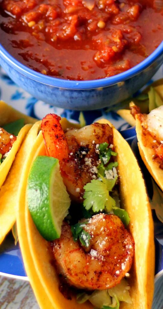 Close up view of a shrimp street taco, focusing on the texture of the shrimp.