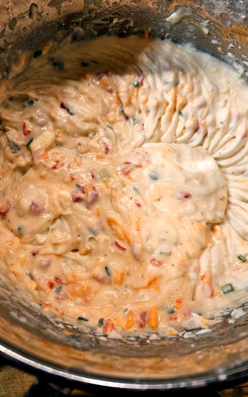 Whipped mashed potatoes with pimentos and cheddar cheese mixed into them.